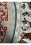 A close-up on the fringe and intricate border of the Persian Qum silk rug, displaying exceptional weaving skills