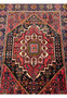 Full view of a Persian Gholtogh rug on the floor, showcasing the complex design and traditional motifs.