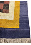 Close-up of the modern Nepal rug's edge, displaying the luxurious golden yellow and indigo border against the plush checkerboard pattern.