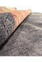Edge-on perspective of the rolled Modern Tibet Rug, showing the layered design and thickness