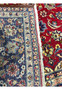 A close-up edge view of a 10 x 15'6" Persian Isfahan rug, emphasizing the detailed border and the back of the rug showing the amazing weaving technique with deep navy blue and vibrant floral patterns on a cream background