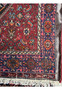 Partial view of a Persian Gholtogh rug, emphasizing the side border and fringe details, with a partial view of the rug's back showing a leather non slip and the magnifcient weaving technique