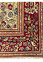 The corner section of the rug, highlighting the intersection of the borders and the central field’s floral design.