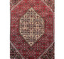 Overhead shot of the Persian Bijar rug, emphasizing the complex patterns and color harmony