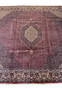 The corner of a 12x12 Persian Bijar rug, illustrating the enlarged floral designs that complement the rug's central medallion and geometric patterns