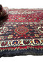 A side view of the Persian Qum Kork rug, with a portion rolled over to reveal the thickness and quality of the Kork wool weave.