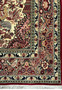 Zoomed-in view of the rug's central design, highlighting the complex interplay of floral motifs, paisleys, and animal figures in a traditional Persian style.