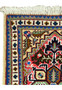 A close-up of the upper half of the Persian Tabriz rug, with a focus on the complex border patterns in blue, gold, and red, and the fine silk threads that add a subtle sheen