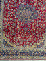 Lower edge of the Persian Isfahan rug, with a focus on the elaborate border designs and the precise detail of the weft and warp threads, indicating the high level of artisanal skill