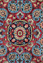 Close-up view on the upper part of a Persian Bijar rug highlighting navy blue, red, and ivory patterns, demonstrating the meticulous craftsmanship of the hand-knotted wool design