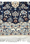 Bottom border of Persian Nain rug with fringes and floral trim