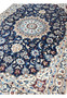 Angle view showing medallion and floral vines in rich tones Nain Persian Rug