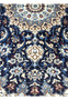 Detail of floral motifs on navy background of handmade Persian rug