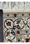 Close-up of rug's underside showing detailed knotting and fringe