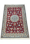 Angled view of Persian Nain rug highlighting medallion and red field