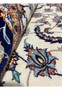 Close-up of Persian Isfahan runner rolled to show soft ivory wool field with blue and rust floral patterns. Close-up of Persian Isfahan runner rolled to show soft ivory wool field with blue and rust floral patterns.