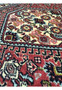 Wool closeup of Bijar Poshti Persian rug highlighting hand-knotted floral motifs in red, ivory, blue, and green.