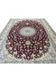Wine red field with floral vine motifs and silk highlights on Persian Nain 9 LAA rug