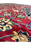Close-up of vibrant red field and floral motifs on Persian Mashad Rug highlighting wool texture