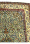 Upper corner of 9'4 x 14'5 Persian Tabriz rug showing light sage-green field, ivory floral border, and intricate vine motifs