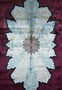 Close-up of central floral medallion on 6x9’5 Chinese silk oriental rug with sky-blue and ivory tones Close-up of central floral medallion on 6x9’5 Chinese silk oriental rug with sky-blue and ivory tones