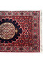 Close-up of Persian Bijar runner’s top corner showing crimson field, navy medallion, ivory border, and fine sky-blue floral detail.
