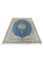 Angled view of hand-knotted royal blue Nain 6 LA rug laid flat showing floral medallion design.
