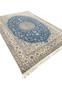 ngled perspective of royal blue Persian Nain rug with ivory border and medallion design.