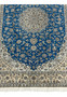 Close-up of ivory border and royal blue field with fine silk floral motifs on Persian Nain 6 LA rug.