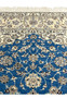 Royal blue field with ivory border and floral vines on Persian Nain rug upper section.