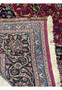 Close-up of the backside of Mashad rug corner showing cotton fringe, blue guard border, and precise hand-knotted details.