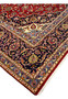 Edge and corner of Persian Kashan rug 9x13 navy border floral vines visible fading
