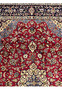 Upper border of 8'5 x 11'8 Persian Isfahan rug with red floral field and light blue corner spandrels.