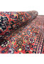 Rolled angle view highlighting the thick wool pile and detailed floral pattern of the Bijar Persian Iron Rug.