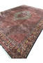 Angled low view of the 9'9 x 13'2 Bijar Persian Iron Rug showing the large cream medallion and brick red Herati field.