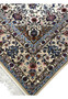 Detailed corner and fringe view showing beige borders, blue accents, and fine floral work of the Isfahan rug.