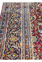 Side perspective of a Persian Kashan rug showing patina and floral motifs.
