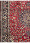 Side angle of Persian Isfahan rug highlighting medallion, floral patterns, and navy border design