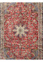 Close-up of the midfield showing the vintage Najafabad floral patterns with ruby red background and ivory vinework.