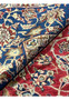 Rolled section of a vintage Najafabad Persian rug showcasing dense floral patterns in red, blue and ivory tones.