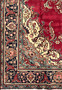 Border close-up of the Patina Tabriz Rug with navy floral motifs, guard stripes, and visible wear in the pile.