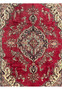 Midfield close-up of the vintage Tabriz rug showing patina, low pile, red background, and intricate floral vine details.