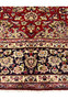 Border closeup of red Persian Isfahan rug showing navy floral motifs and guard stripes