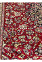 Color closeup of red field Persian Isfahan rug showing detailed floral weaving