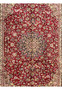 Midfield closeup of red Persian Isfahan rug showing dense floral motifs around medallion