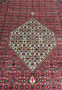Central ivory diamond medallion on Persian Bijar iron rug filled with micro floral motifs over rich crimson and dark navy background