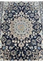 Midfield detail of Persian Nain rug with dark navy blue field, ivory floral vines, sky blue flowers, and soft gold accents