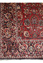 Close view of the all over floral midfield on a 6'6 x 9'6 Persian Bijar iron rug with brick red and navy tones
