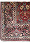 Border detail of Bijar iron rug with dark navy and oxblood red frame, ivory rosettes, diamond medallions, and vine scrolls