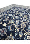 Detailed close-up of Persian Nain rug floral pattern with ivory blossoms, light blue vines, and precision knot structure